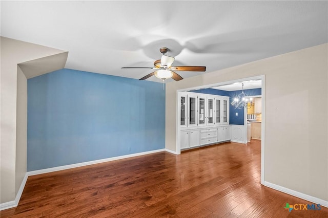 interior space with ceiling fan with notable chandelier and hardwood / wood-style floors