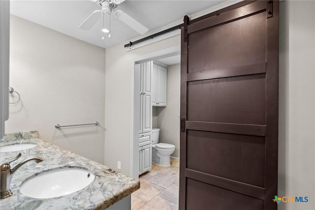 bathroom featuring vanity, ceiling fan, and toilet