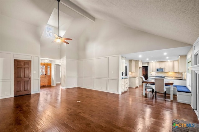 living room featuring vaulted ceiling with beams, a textured ceiling, dark hardwood / wood-style floors, and ceiling fan