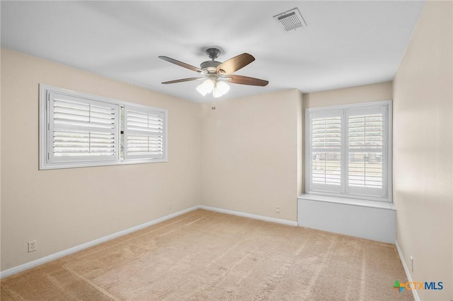 carpeted spare room featuring ceiling fan