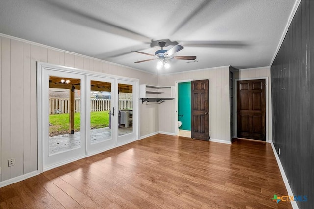 interior space with hardwood / wood-style floors, crown molding, a textured ceiling, and ceiling fan