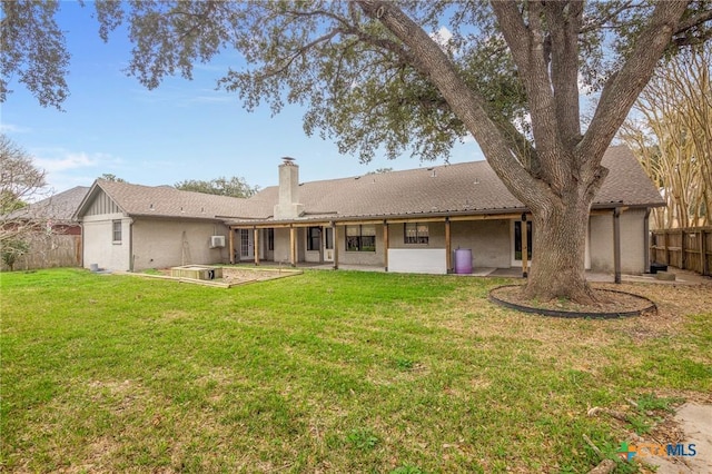 back of property with a patio area and a lawn