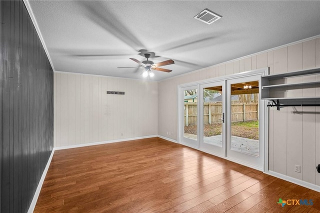 unfurnished room featuring crown molding, hardwood / wood-style floors, and a textured ceiling