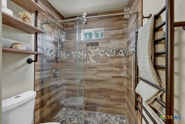 bathroom featuring walk in shower and toilet