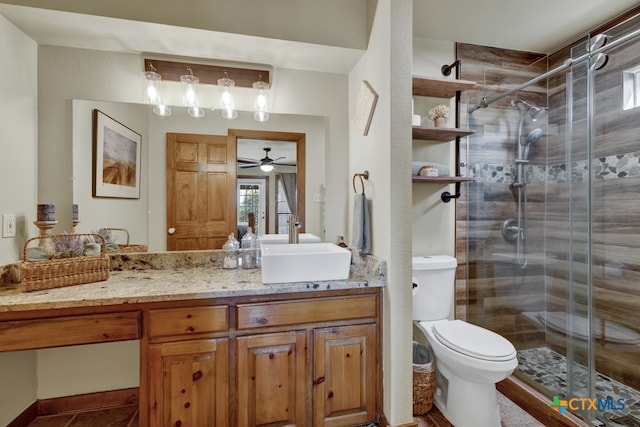 bathroom featuring toilet, an enclosed shower, vanity, and ceiling fan