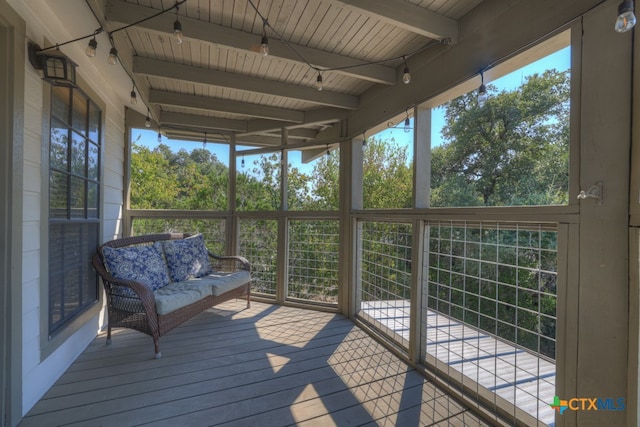 unfurnished sunroom featuring wood ceiling and beam ceiling