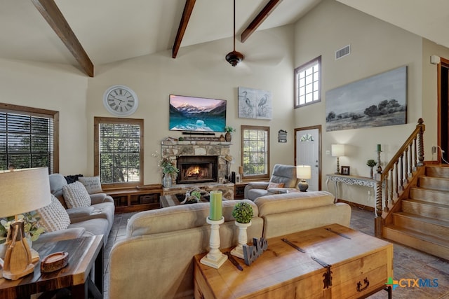 living room featuring a fireplace, a high ceiling, ceiling fan, and beam ceiling