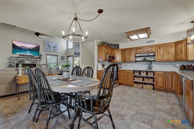 dining area featuring a fireplace, a chandelier, and sink