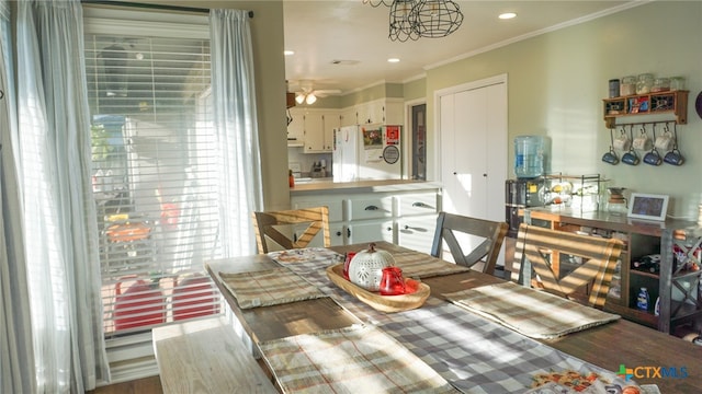 dining area featuring hardwood / wood-style floors, ceiling fan, and crown molding