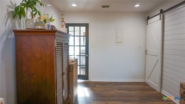 entryway with a barn door, electric panel, and dark hardwood / wood-style floors