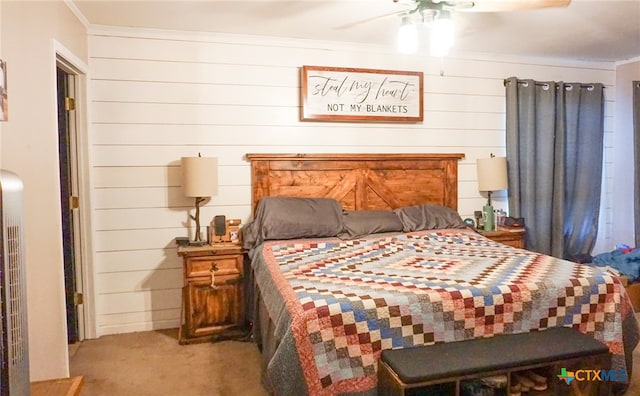 bedroom with carpet flooring, ceiling fan, crown molding, and wooden walls