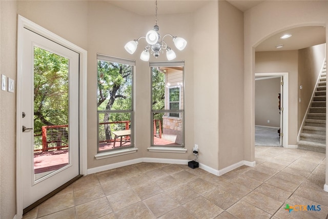 2291 Frontier, Spring Branch, TX 78070 - unfurnished dining area featuring a chandelier, stairway, arched walkways, and a high ceiling