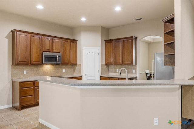 2291 Frontier, Spring Branch, TX 78070 - kitchen with stainless steel appliances, open shelves, arched walkways, backsplash, and light countertops