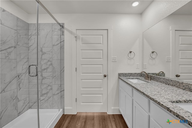 bathroom featuring hardwood / wood-style flooring, vanity, and a shower with door