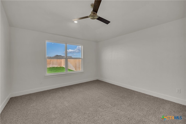 carpeted spare room with ceiling fan