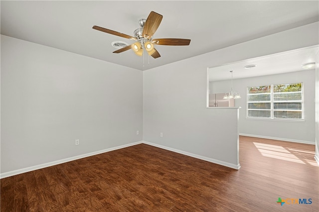 unfurnished room with ceiling fan with notable chandelier and wood-type flooring