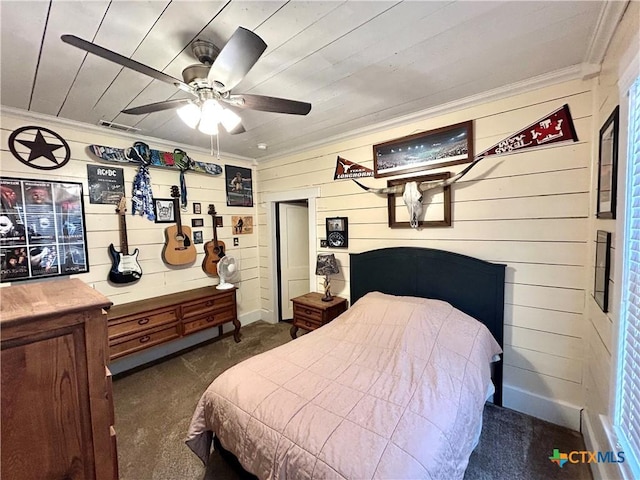 bedroom with crown molding, wooden walls, and dark colored carpet