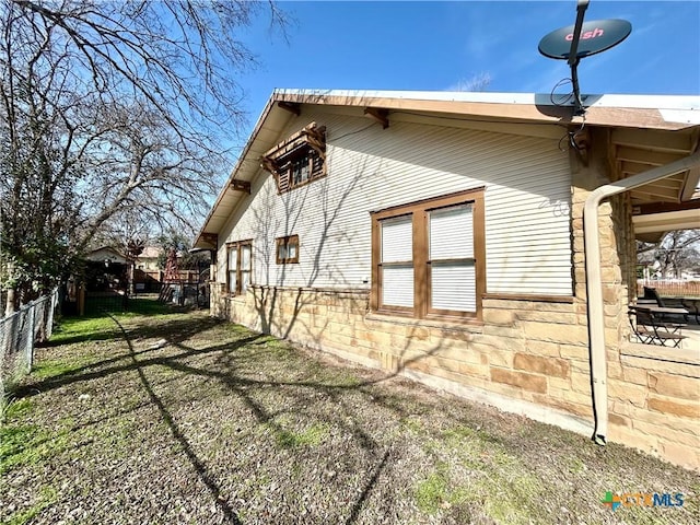 view of side of home with a yard