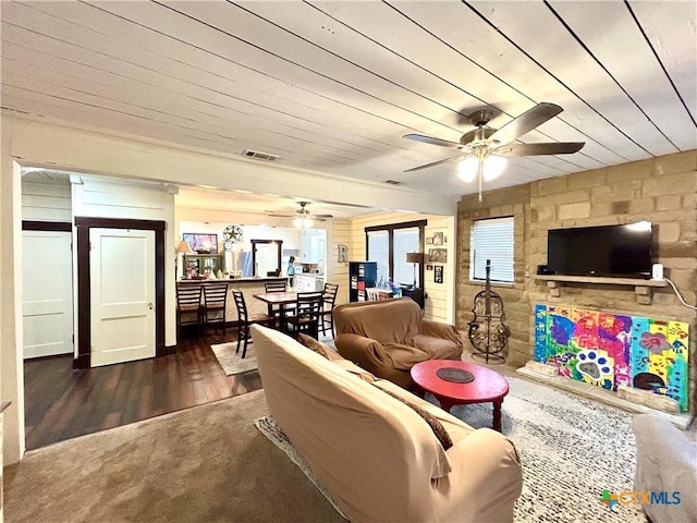 living room featuring dark wood-type flooring, wooden ceiling, and ceiling fan