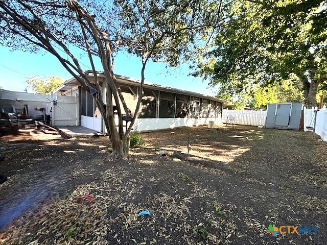 rear view of house featuring a storage unit