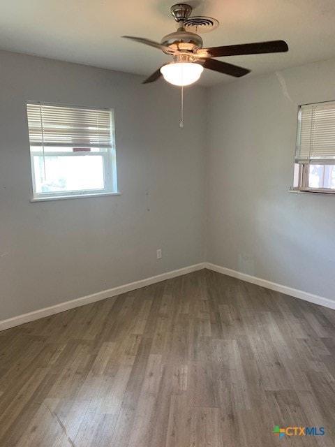 spare room with hardwood / wood-style flooring and ceiling fan