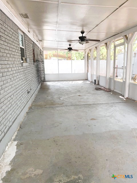 unfurnished sunroom with ceiling fan