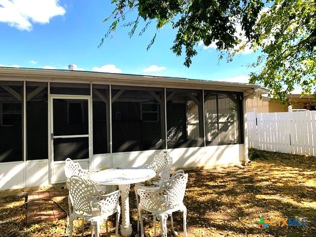 back of property with a sunroom