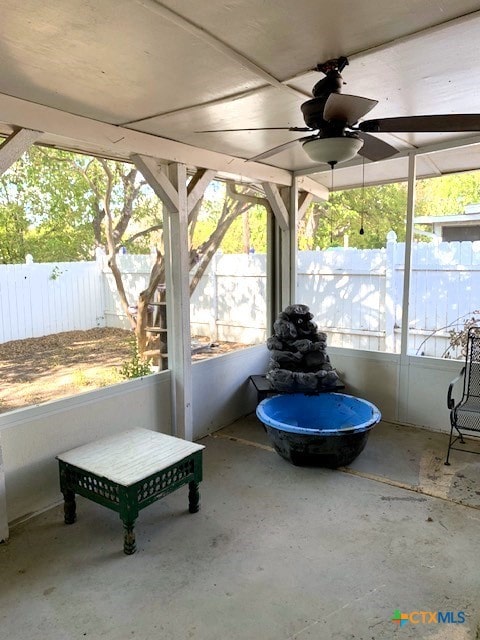 unfurnished sunroom featuring ceiling fan and plenty of natural light