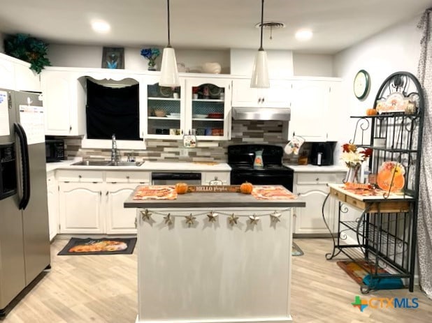 kitchen with sink, hanging light fixtures, light hardwood / wood-style flooring, appliances with stainless steel finishes, and white cabinetry