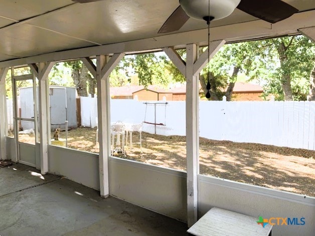 unfurnished sunroom featuring ceiling fan