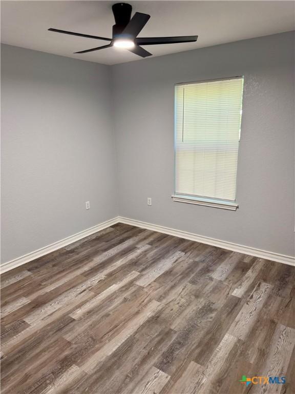 1037 N Guadalupe St, Seguin, TX 78155 - empty room featuring ceiling fan, dark wood finished floors, and baseboards