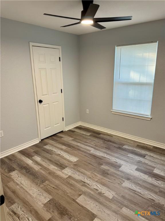 1037 N Guadalupe St, Seguin, TX 78155 - empty room featuring ceiling fan, wood finished floors, and baseboards