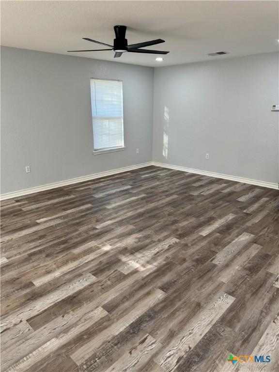 1037 N Guadalupe St, Seguin, TX 78155 - empty room featuring dark wood-style flooring, ceiling fan, and baseboards