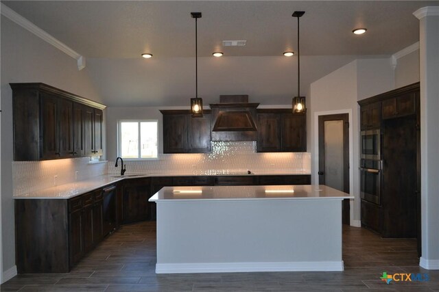 kitchen featuring stainless steel appliances, premium range hood, a kitchen island, and decorative light fixtures