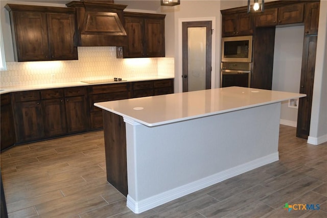 kitchen with built in microwave, oven, and a kitchen island