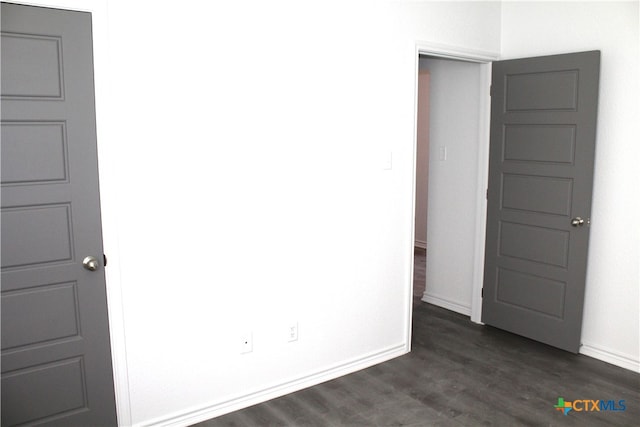 unfurnished room with dark hardwood / wood-style floors