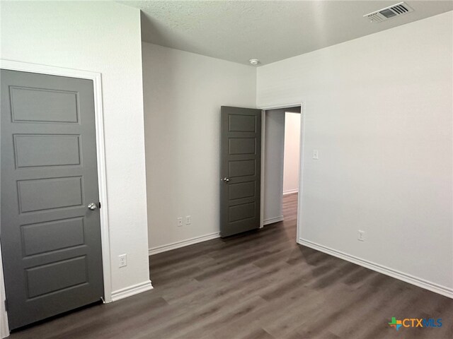 2226 Wooster St, Nolanville, TX 76559 - unfurnished bedroom featuring dark wood-type flooring, visible vents, and baseboards