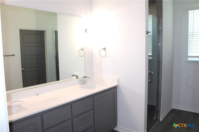 bathroom featuring vanity and a shower with shower door