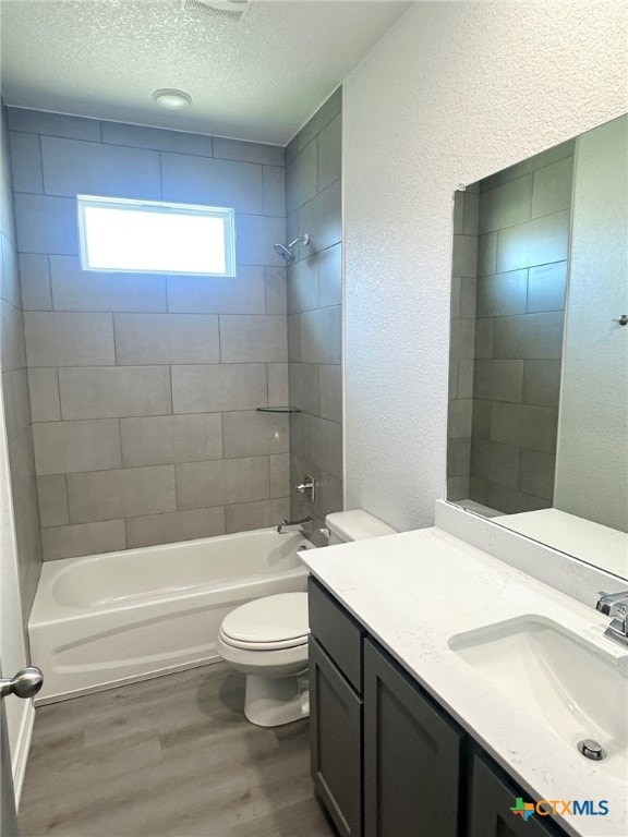 2226 Wooster St, Nolanville, TX 76559 - full bath with a textured ceiling, toilet, wood finished floors, washtub / shower combination, and a textured wall