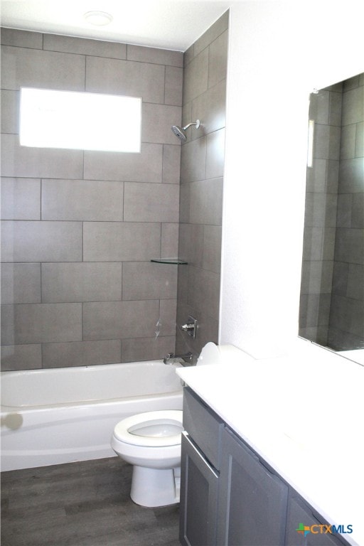 full bathroom with vanity, wood-type flooring, tiled shower / bath combo, and toilet