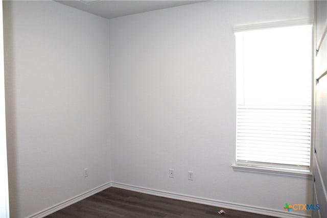 unfurnished room with dark wood-type flooring