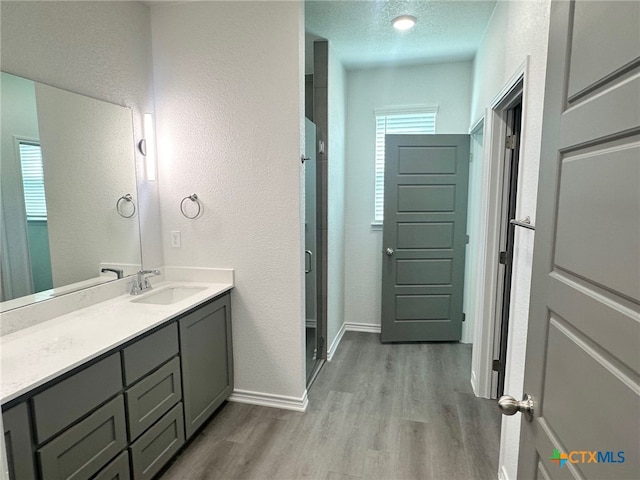 2226 Wooster St, Nolanville, TX 76559 - full bathroom featuring baseboards, a textured wall, vanity, wood finished floors, and a stall shower