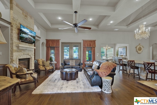 living room featuring ceiling fan with notable chandelier, coffered ceiling, dark hardwood / wood-style floors, beam ceiling, and a fireplace