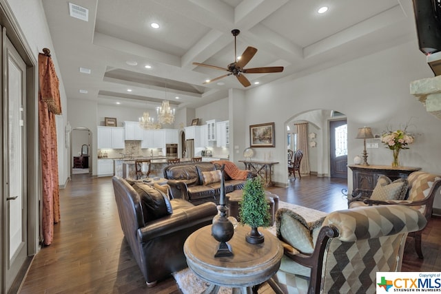 living room featuring beamed ceiling, coffered ceiling, dark hardwood / wood-style floors, and ceiling fan with notable chandelier