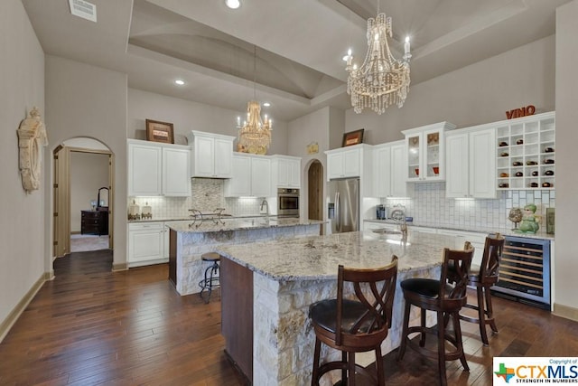 505 Cantera Rdg, New Braunfels, TX 78132 - kitchen with a large island with sink, stainless steel appliances, arched walkways, a towering ceiling, and recessed lighting