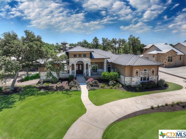 505 Cantera Rdg, New Braunfels, TX 78132 - mediterranean / spanish house with a standing seam roof, stone siding, a front yard, metal roof, and covered porch