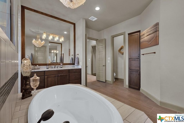 505 Cantera Rdg, New Braunfels, TX 78132 - full bath featuring a chandelier, a jetted tub, vanity, baseboards, and toilet