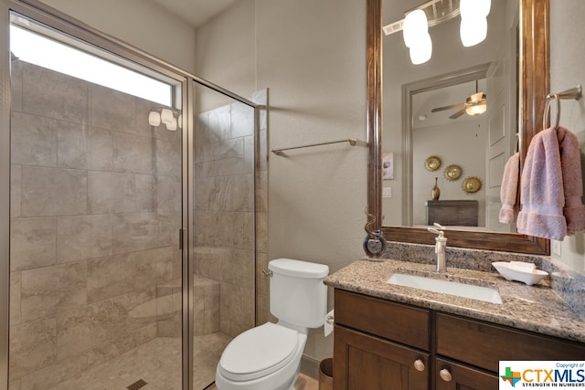 bathroom featuring walk in shower, ceiling fan, vanity, and toilet