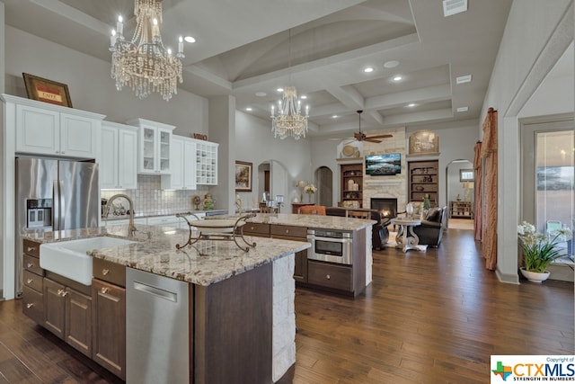 kitchen featuring stainless steel appliances, white cabinetry, dark hardwood / wood-style flooring, sink, and a spacious island