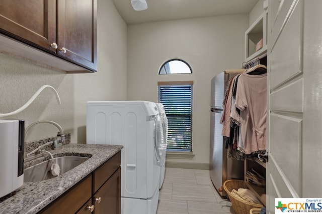 laundry area with cabinets, washer and dryer, and sink